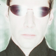 A closeup of Keanu Reeves' Neo bathed in white light and wearing sunglasses in The Matrix: Reloaded.
